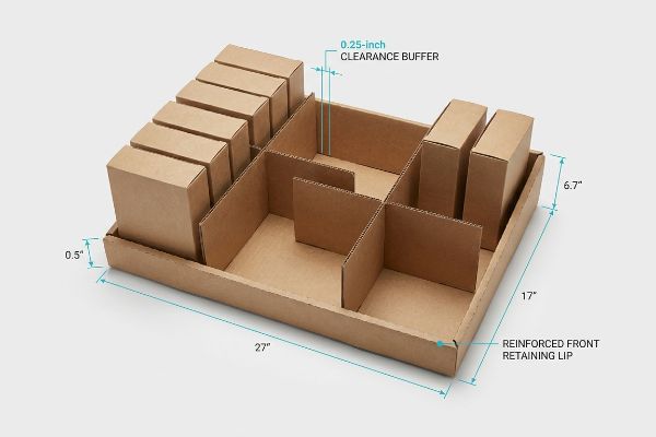 Brown corrugated display tray with modular dividers, featuring a 0.25-inch Clearance Buffer and Reinforced Front Retaining Lip.