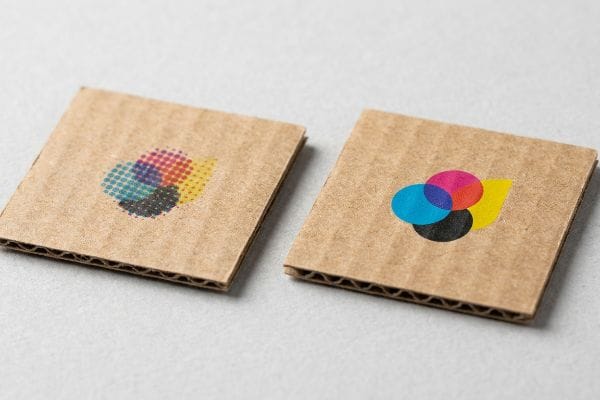 Les morceaux de carton ondulé mettent en valeur la qualité d'impression CMJN, contrastant les points de trame granuleux avec des couleurs unies nettes pour un rendu percutant.