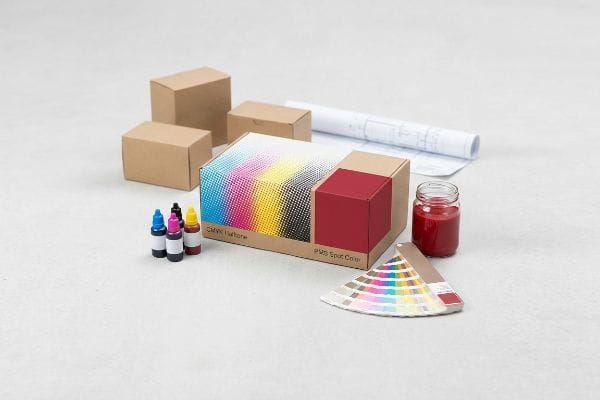 CMYK PMS Printing Supplies A collection of printing supplies featuring a cardboard box with Cmyk Halftone and Pms Spot Color, ink bottles, and a Pantone swatch book.