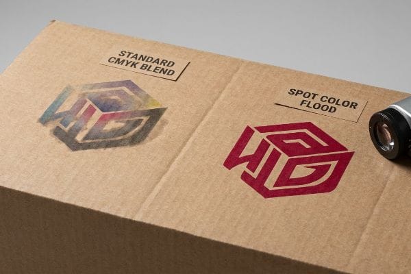Brown corrugated testliner displays a logo printed with Standard CMYK Blend vs. vibrant Spot Color Flood for superior branding.