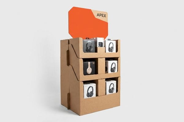 Corrugated cardboard retail merchandising display with an orange die-cut Apex header, showcasing three tiers of boxed headphones.