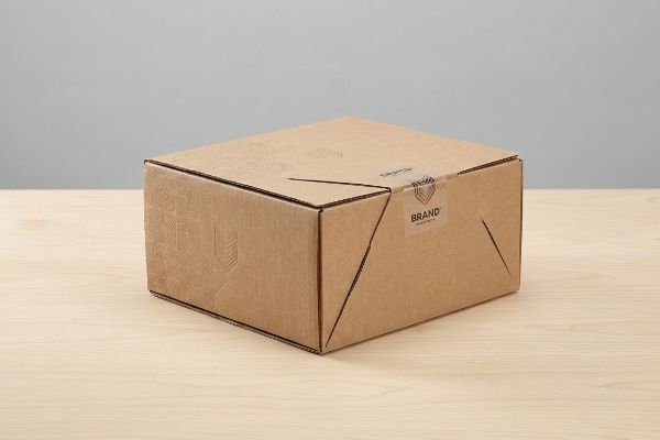 A brown corrugated cardboard box with a 'Brand' label is securely sealed, showcasing custom packaging for product protection and marketing.