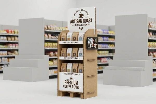 A retail store aisle features a corrugated cardboard POP display for Artisan Roast Limited Edition Premium Coffee Beans, with a digital screen.