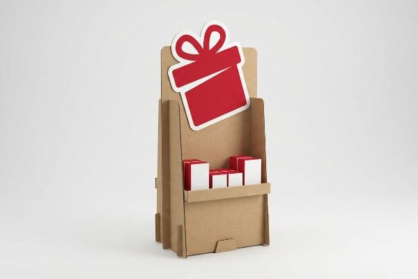 Brown corrugated cardboard POP display stand with an oversized red die-cut gift box header and small red-white boxes on a shelf.