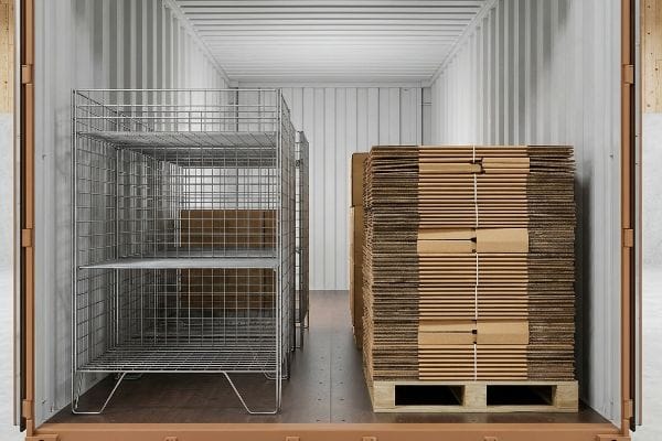 Collapsible wire mesh racks and flat-pack corrugated cardboard boxes inside a shipping container, demonstrating freight volume efficiency.