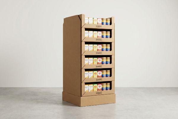 A retail floor standing display unit made of brown corrugated cardboard, showcasing six shelves of small Spiced product boxes.