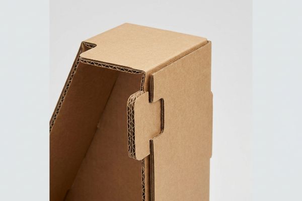 Close-up of a corrugated cardboard interlocking tab and die-cut slot, revealing B-flute edges for a PDQ box assembly.