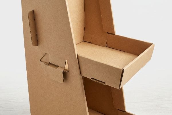 Natural brown corrugated cardboard display stand with visible flutes, featuring interlocking tabs and an empty shelf, demonstrating origami-style paper locks.