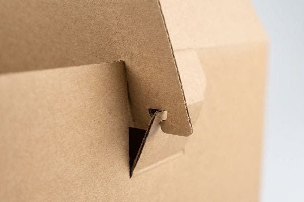 Brown corrugated cardboard interlocking paper lock with a friction tab securing a mono-material joint.