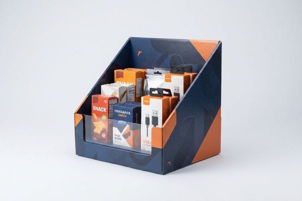 Blue and orange corrugated POS display, geometric patterns, holding Snack and USB products, with a clear retaining lip.