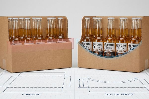 Brown corrugated cardboard display cases with Corona Extra beer bottles, comparing a Standard high retaining lip obscuring labels to a Custom Swoop die-cut for clear label visibility. Blueprints are below.