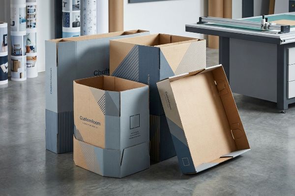 Corrugated CustomRoom and Chaft branded display boxes with blue geometric patterns, for retail pallet wraps.