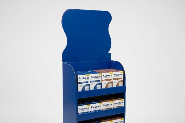 Solid blue corrugated retail display with a curvy die-cut header, presenting Proshrone and Preshrone product boxes.
