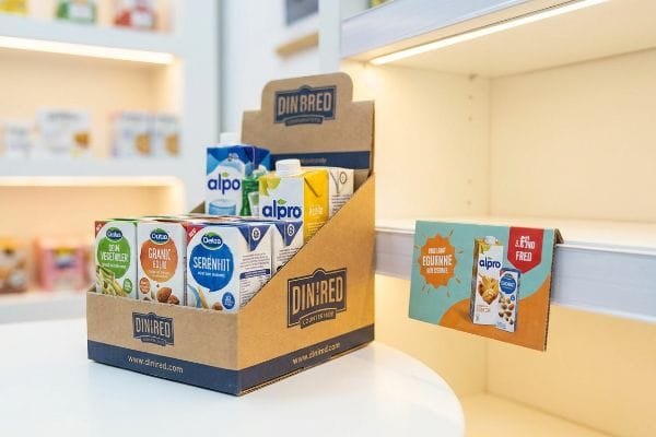 A retail point of purchase display showcases a Din Bred cardboard unit with Alpro and Odeas plant-based milk cartons, including Serenhit, Granic Ekin, and Bean Vegetaler, next to an Alpro and Fred shelf talker.