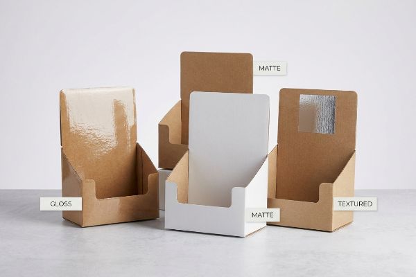 Four countertop display boxes showcase Gloss, Matte (brown and white), and Textured finishes, ideal for retail merchandising.