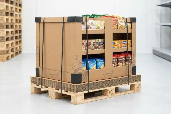 食品を詰めた、自然な茶色の段ボール製ディスプレイ対応パレット。段ボール製のスリップシートで固定された木製のEUR EPALパレットに載せられています。.