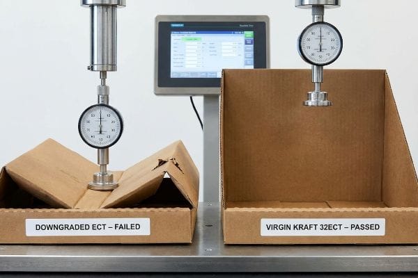 A crushed Downgraded ECT – Failed corrugated box stands next to an intact Virgin Kraft 32ECT – Passed box during a compression test.