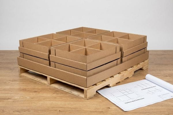 Brown corrugated cardboard E-Flute Modular Dividers and Fractional Base Subdivisions on a wooden pallet with a blueprint.