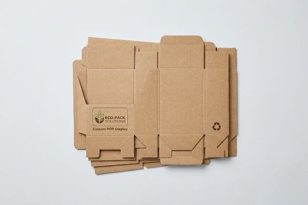 Flat-packed corrugated POP displays by Eco-Pack Solutions, with Custom POP Display branding and a recycling symbol.