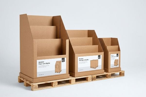 Présentoirs modulaires pour palettes Présentoirs modulaires en carton kraft brun, présentés au sol, sur demi-palette et quart de palette, sur une palette en bois, illustrant des solutions de merchandising pour le commerce de détail.