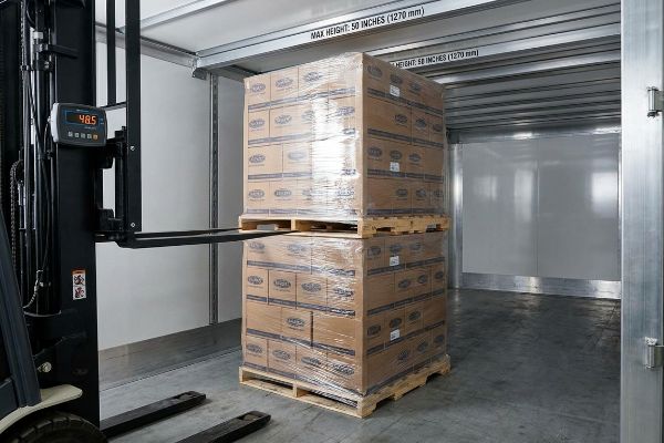 A forklift's digital display shows 48.5, positioned near double-stacked pallets of boxes inside a cargo trailer with a Max Height: 50 Inches (1270 Mm) sign.