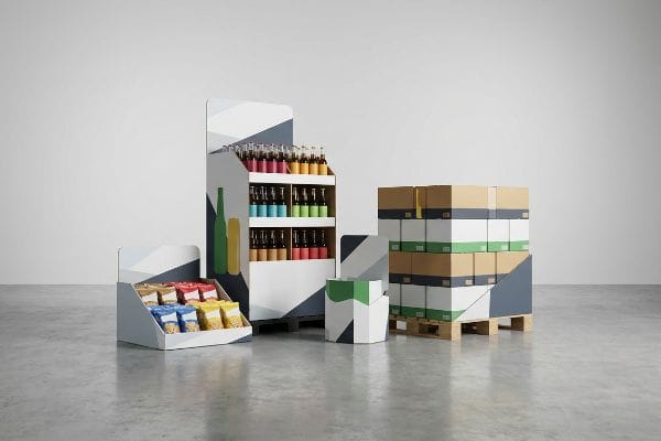 Présentoirs géométriques pour la vente au détail : présentoir de sol avec bouteilles, présentoir de comptoir avec collations et caisses de présentation sur palette.