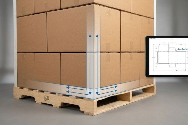 Empilage GMA sans surplomb Une palette GMA chargée de boîtes en carton brun, des flèches bleues soulignant l'alignement vertical et horizontal des coins, à côté d'une tablette montrant une ligne de découpe à débordement nul.