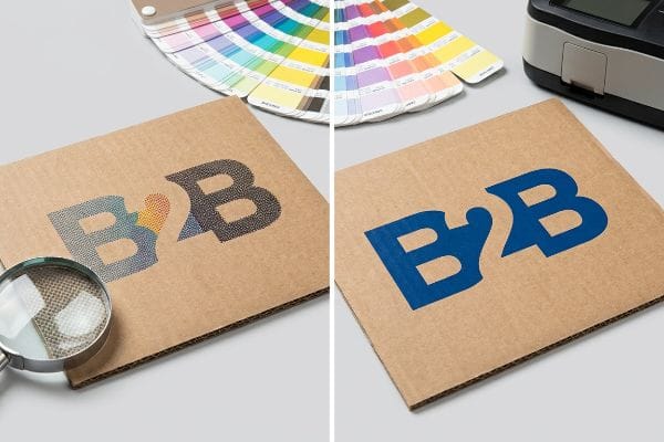 Corrugated cardboard displays two B2B logos, contrasting grainy CMYK halftone dots with dense Pantone spot color printing.
