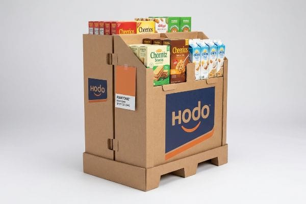 A customized Hodo corrugated cardboard power wing display showcases Cheerios, Chornitz Snacks, and oat milk, featuring Pantone Spot Colors.