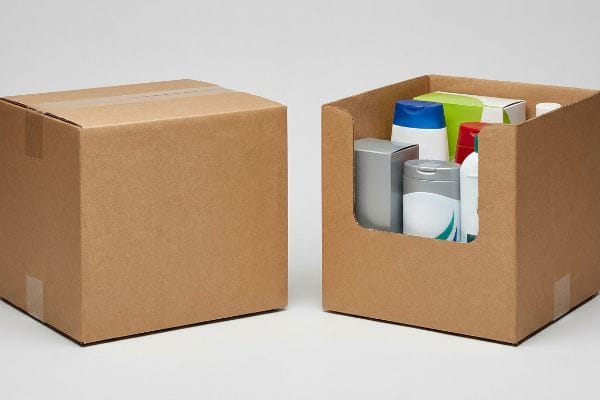 Natural brown corrugated cardboard boxes, one sealed RSC and one open-top HSC retail display bin filled with personal care products.