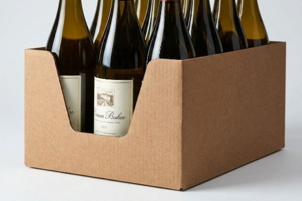 Brown corrugated retail tray with a custom die-cut swoop exposing Simon Baken 2017 wine bottle labels, ensuring TTB compliance.