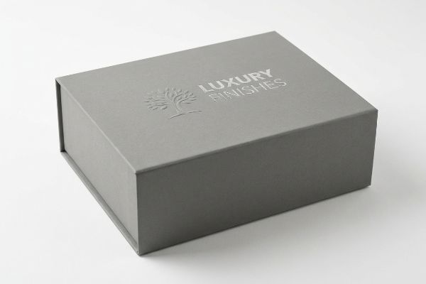 Grey paperboard box featuring a silver embossed 'Luxury Finishes' logo with a tree emblem on its lid.