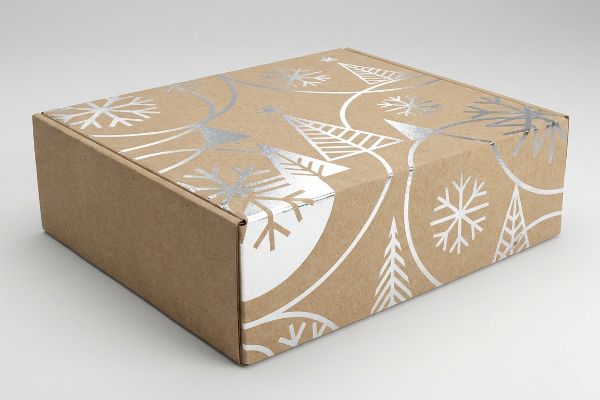 Caixa de papelão ondulado marrom com impressão em folha metálica prateada de flocos de neve e árvores de Natal, exibindo uma embalagem de inverno premium.
