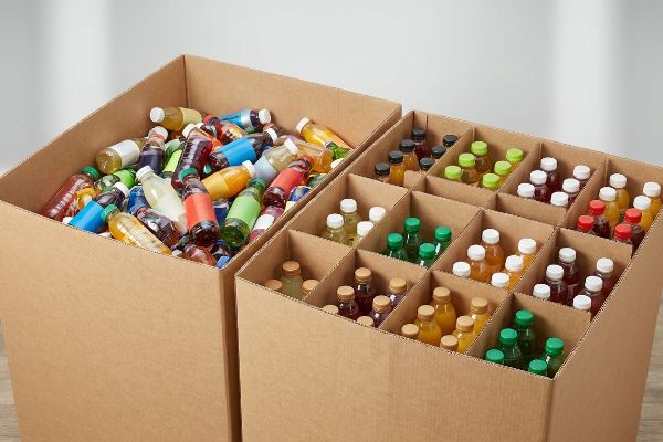 Corrugated cardboard boxes, one with mixed colorful beverage bottles, the other organized by modular SKU dividers for retail.