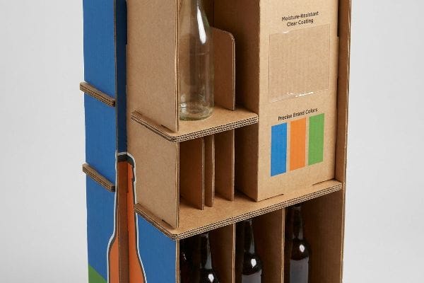 A multi-level corrugated cardboard beverage display features a Moisture-Resistant Clear Coating and Precise Brand Colors, with slots for bottles.