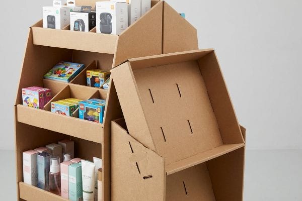 Versatile cardboard display stands filled with Xiaomi electronics, LEGO toys, and cosmetics, alongside empty modular shelves.