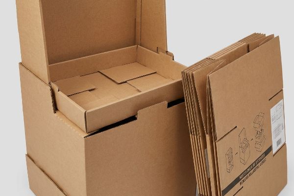 Brown corrugated cardboard boxes demonstrating nested internal tray design and flat-packed components, labeled 'Nested Packing Optimized'.