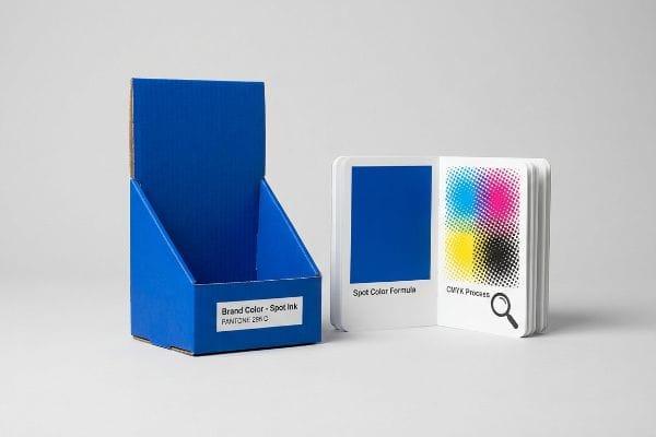 Corrugated display box and color swatch book illustrating Brand Color - Spot Ink Pantone 285C versus CMYK Process.