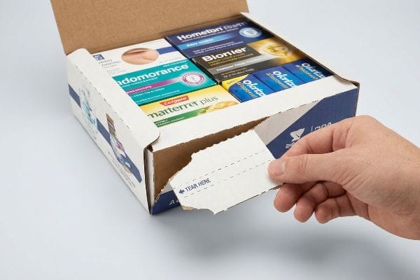 A hand tears a PDQ display package along its 