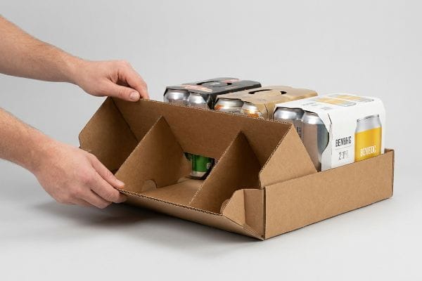 Brown corrugated modular pop-up tray being assembled by hands, holding Benefic beverage multi-packs.
