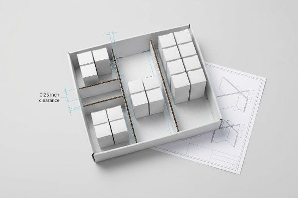 Modular dividers in a white retail tray show 0.25 inch clearance for product grouping, preventing tears during restocking.
