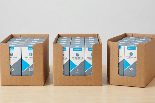 Three brown corrugated PDQ boxes, each filled with Prorgine product boxes displaying '50' units, optimized for retail display.
