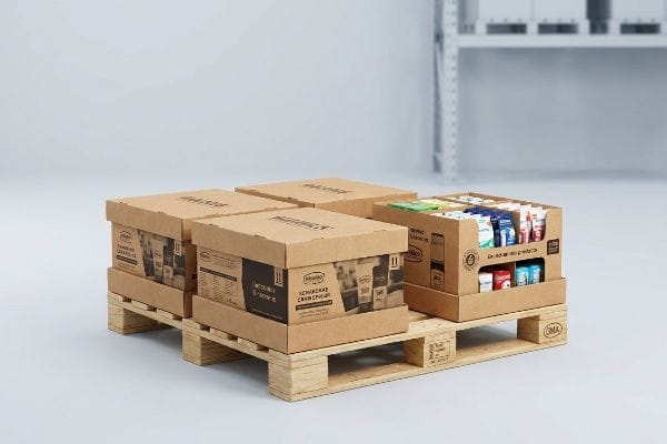 Brown cardboard display boxes, including one open Schwarzkopf product display, arranged on a quarter GMA wooden pallet for retail POP-up.
