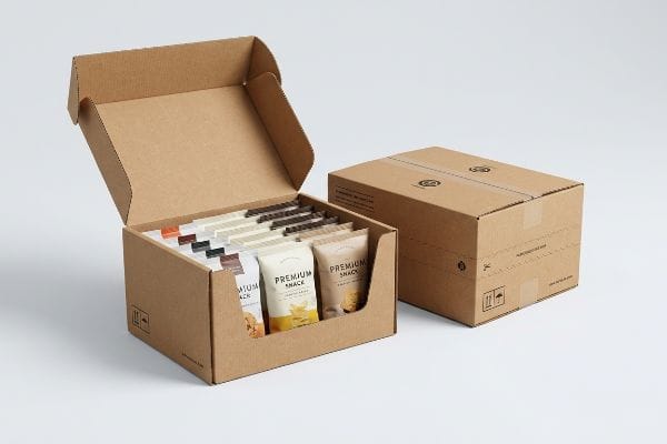 Corrugated retail-ready packaging displays assorted Premium Snack pouches, with a closed shipping box in the background.