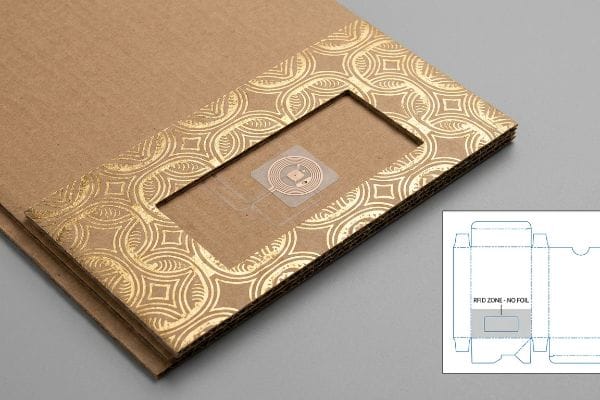 Gold foil corrugated packaging with an exposed RFID tag and a dieline indicating an Rfid Zone - No Foil.