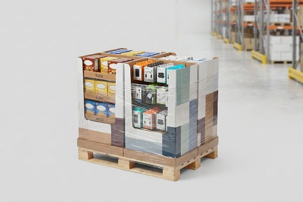 Shrink-wrapped half pallet display featuring food boxes and electronics accessories in a warehouse.