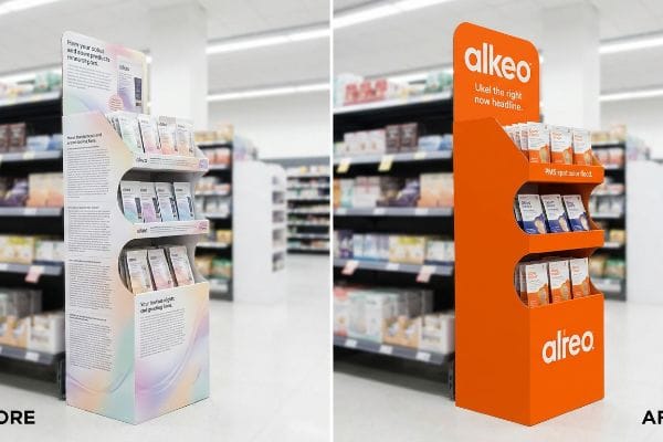 White corrugated retail floor display with subtle pastel gradients and dense marketing text, showcasing Alkeo products in light-colored packaging.