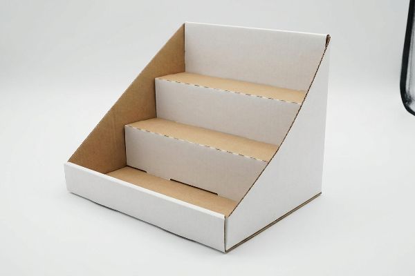 An empty three-tier corrugated cardboard POP display stand, ready for retail merchandising.
