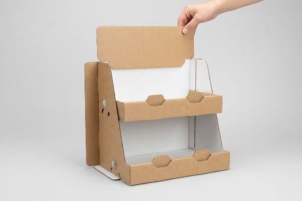 Assemblage d'un présentoir à deux niveaux en carton ondulé brun, mettant en évidence sa conception autobloquante pour une installation sans frustration.