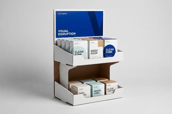 White corrugated two-tier display with 'Visual Disruption' header, showing 'Clean Fonk' and 'Week Poop' boxes on die-cut trays.